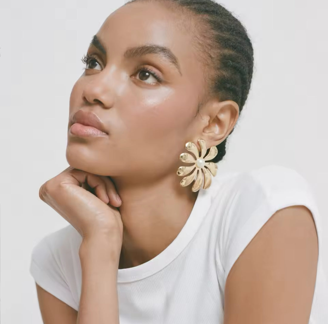 Model wearing GRISÉ NYC gold flower pearl statement earrings.
