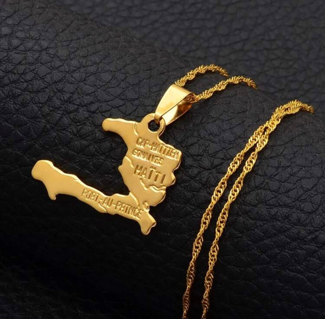 Close-up of gold-tone Haiti pendant necklace featuring raised geographical details and engraved Haitian city names.