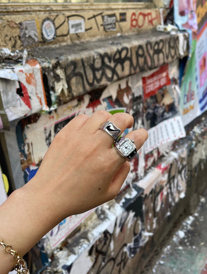Hand wearing GRISÉ NYC Just Do It stainless steel rings styled with everyday streetwear.