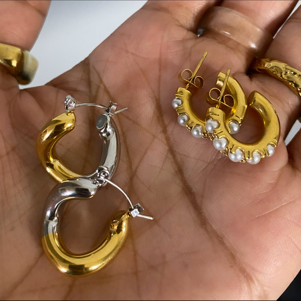 Mini midi pearl hoop earrings with pearl accents held in hand by GRISÉ NYC.