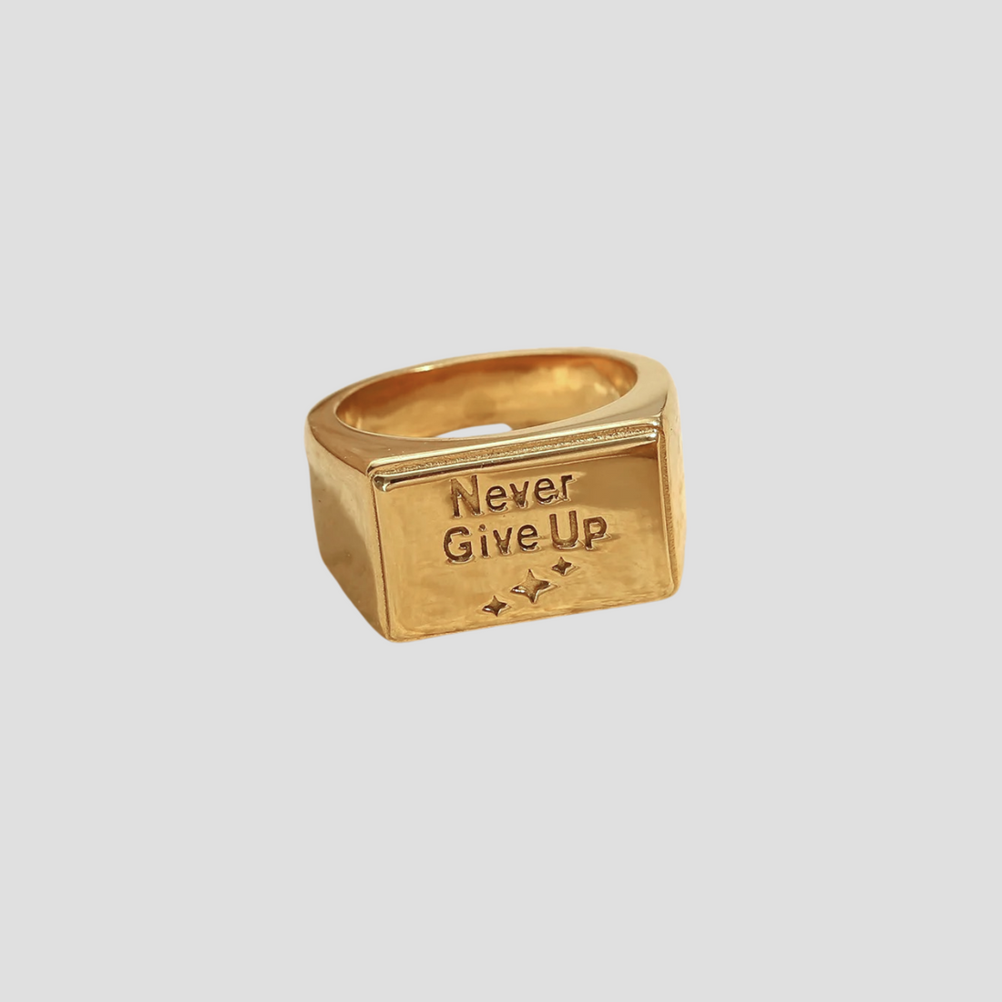 Flat lay of GRISÉ NYC Never Give Up 18k gold plated signet ring.