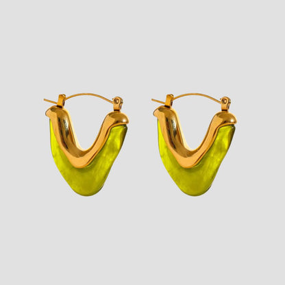 Flat lay of GRISÉ NYC olive resin V-shape 18k gold plated earrings