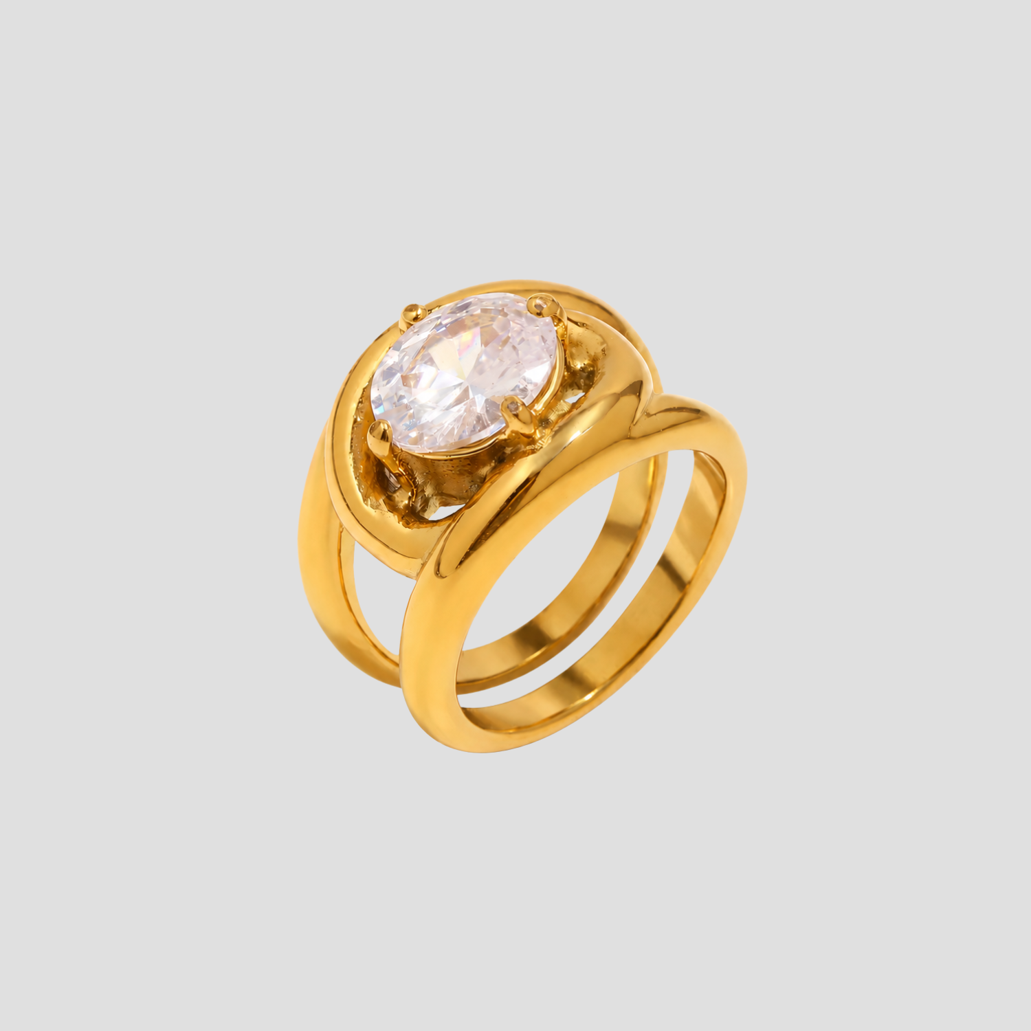 GRISÉ NYC gold statement ring with oversized oval crystal stone on light grey background