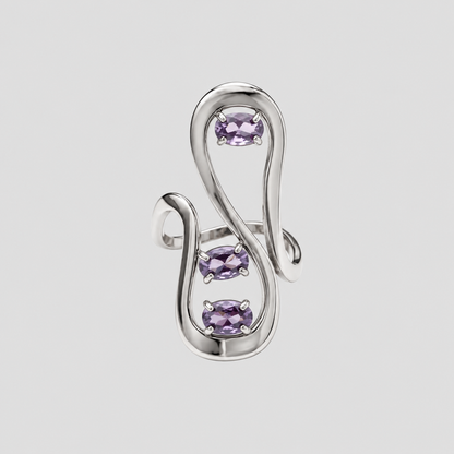 GRISÉ NYC silver sculptural statement ring featuring three oval lavender purple gemstones set within an abstract flowing openwork design against a light grey background.