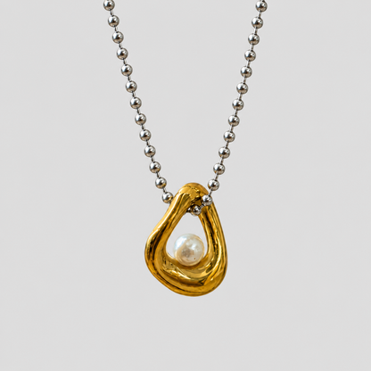 Flat lay of GRISÉ NYC two-tone pearl gold plated necklace.