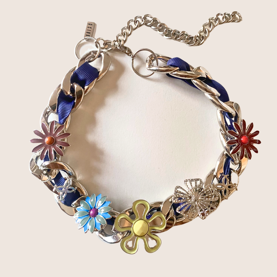XL Cuban Link Charm Necklace with blue woven chain, colorful flower charms, and mixed metal details on a neutral background.
