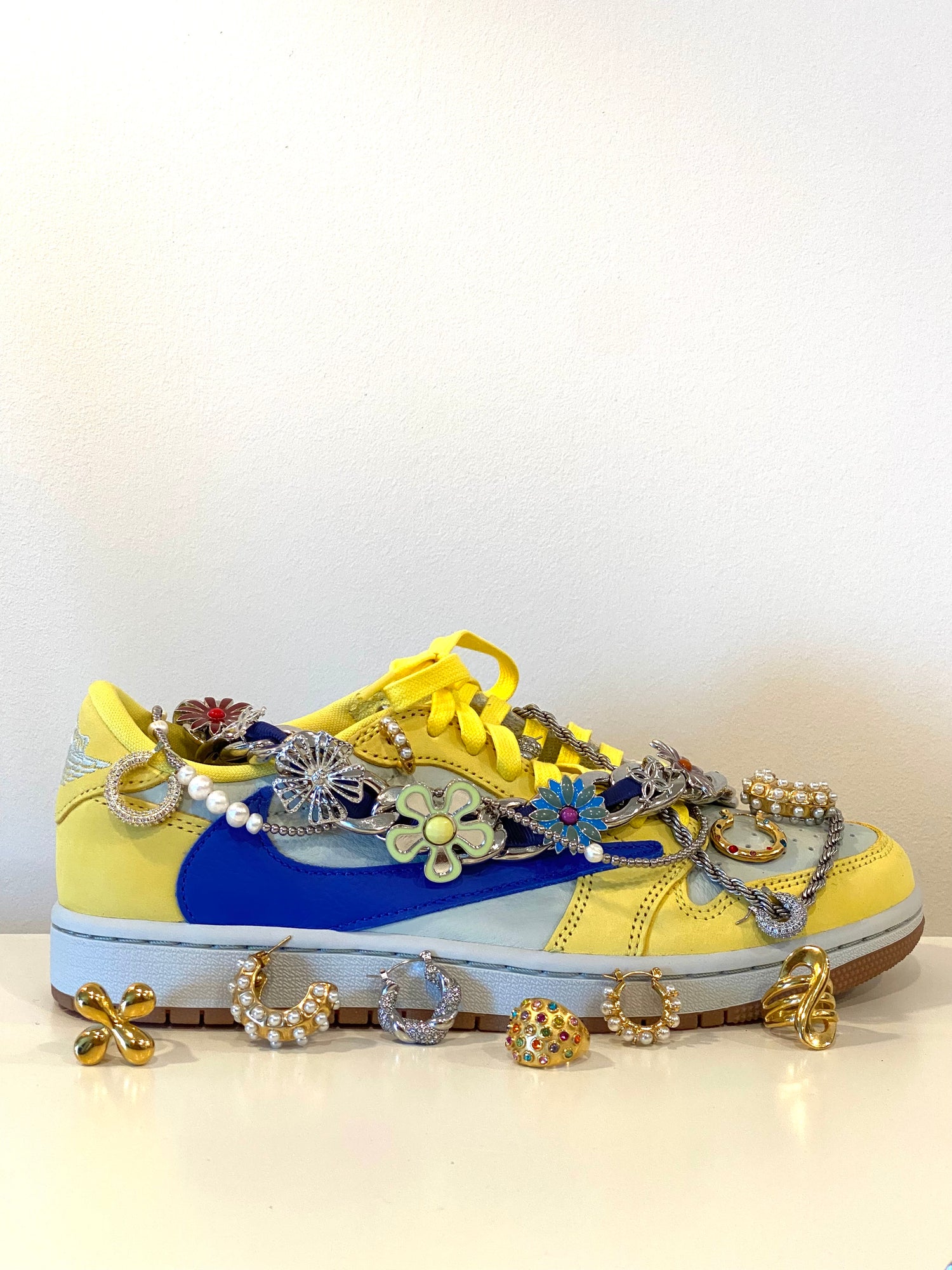 GRISÉ NYC XL Cuban Link Charm Necklace styled by Georgina Ogirri with colorful sneakers, showcasing floral charms, mixed metals, and woven blue chain details.