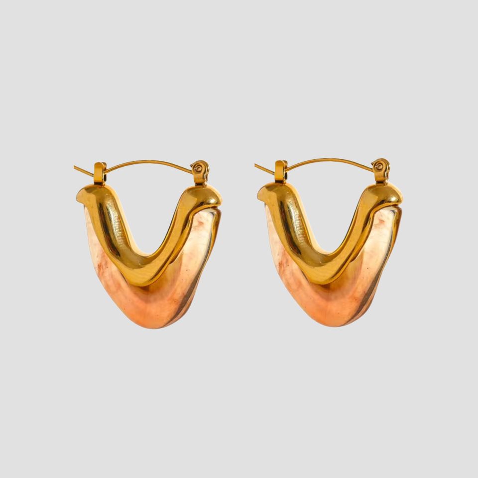 Tortoise resin V shape gold hoop earrings on gray background