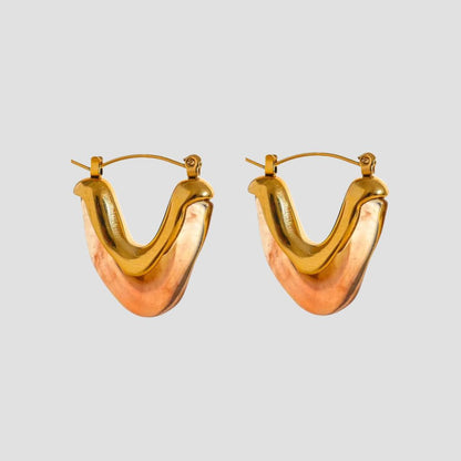 Tortoise resin V shape gold hoop earrings on gray background