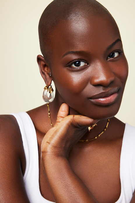 Close up of model wearing twisted snake chain gold necklace GRISÉ NYC statement jewelry.
