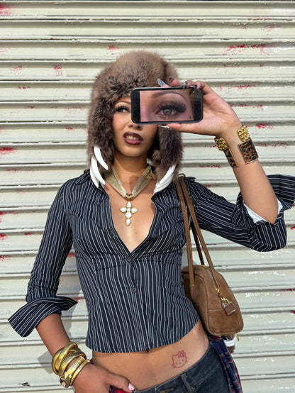 Model taking a selfie with a phone, wearing the gold plated cross pendant necklace with white quartz stones on mesh chain by GRISE NYC.