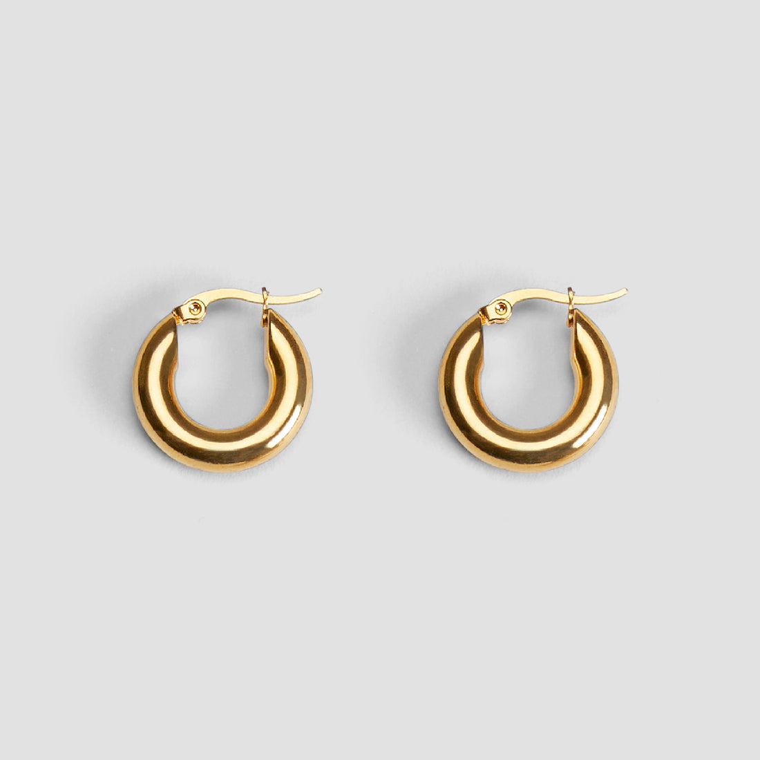Pair of 20 mm mini hoop earrings in 18K gold-plated stainless steel by GRISÉ NYC.