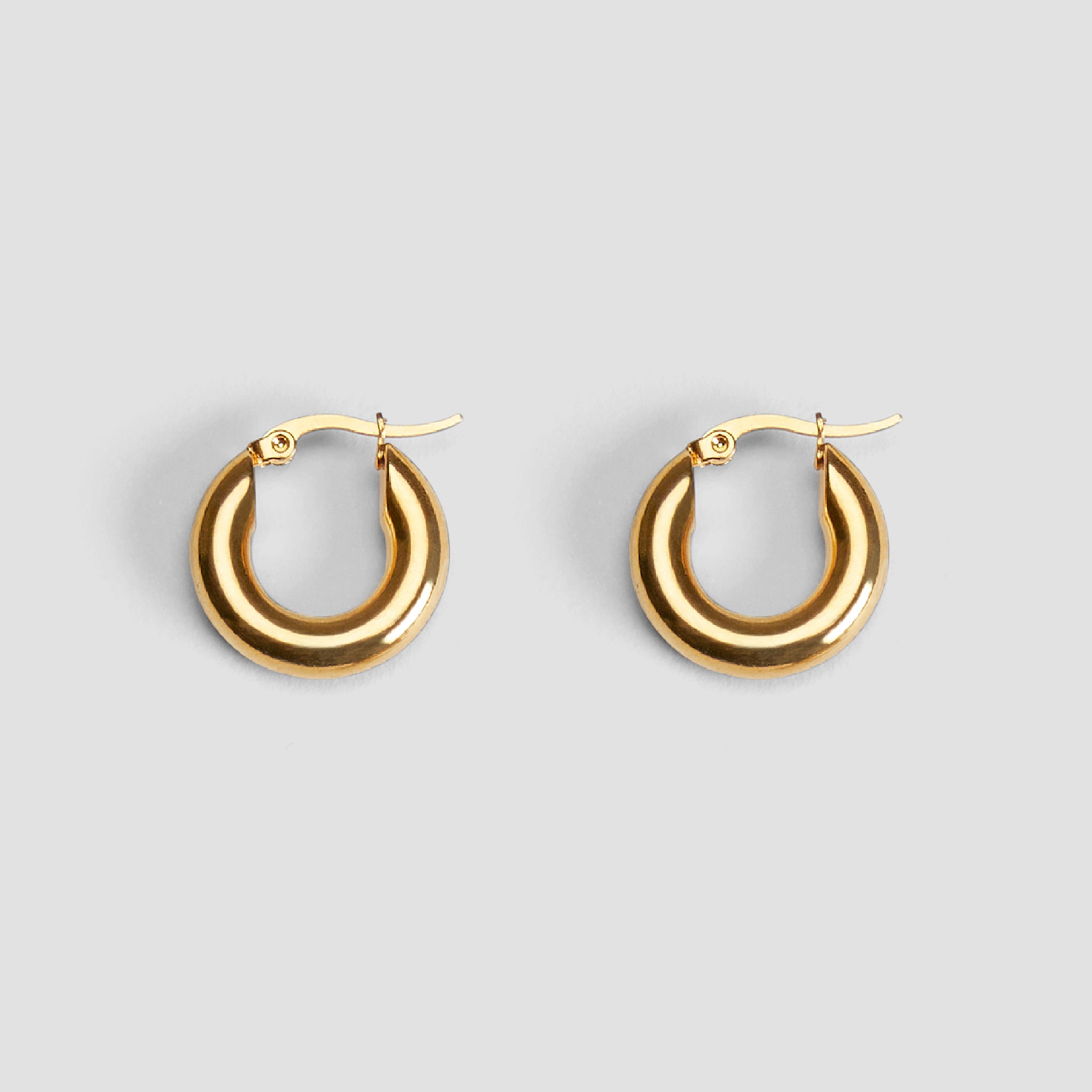 Pair of 20 mm mini hoop earrings in 18K gold-plated stainless steel by GRISÉ NYC.