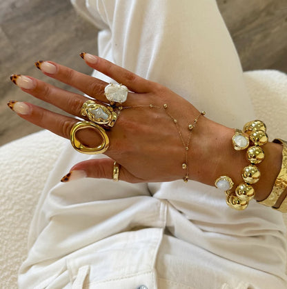 Mother of Perlita Cross gold signet ring styled with other GRISÉ NYC rings on model hand.