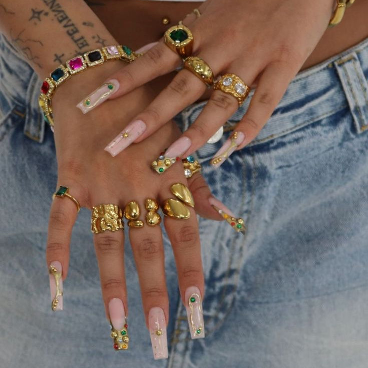 Styled shot of hands stacked with GRISÉ NYC gold rings including the Molten Gemstone 18k Gold Ring, showcasing layered statement looks.