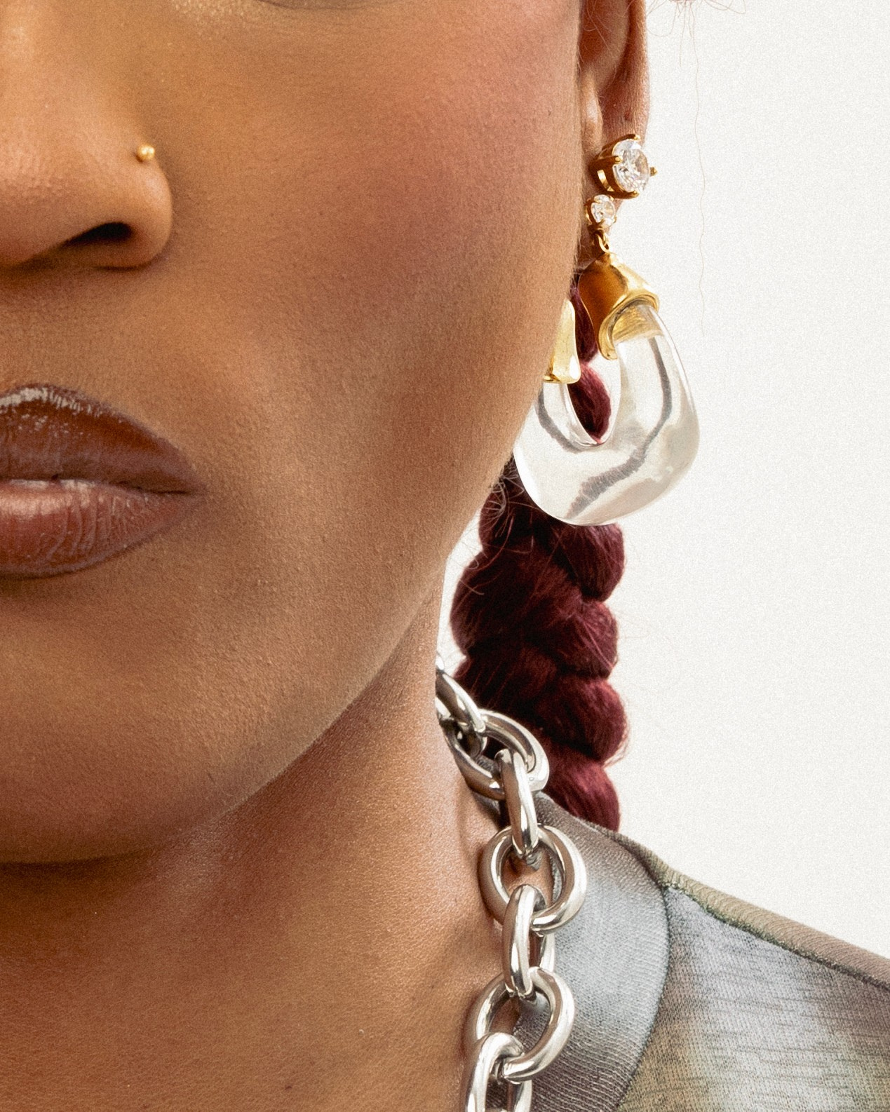 Close-Up: Clear resin gold hoop earrings worn on model sculptural design