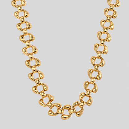 The Sovereign 18k gold plated necklace with a distinctive interlocking loop link design, displayed against a solid light gray background. 