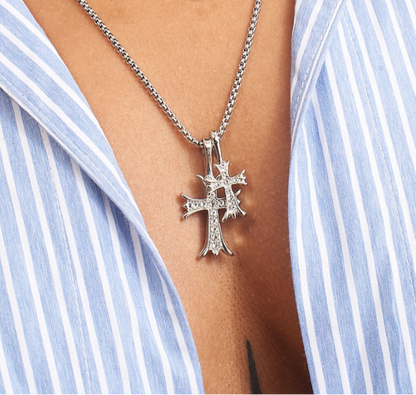 Close up of GRISÉ NYC’s double cross pendant stainless steel necklace with cubic zirconia stones.